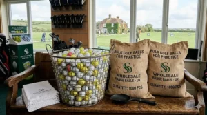 A golfer using a premium hitting net in a British garden, surrounded by bulk golf balls for practice on a synthetic turf mat.