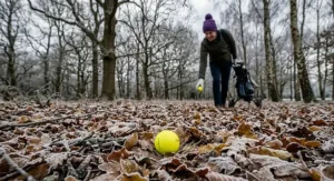 Alt text for image 8: A British golfer's winter kit including a woolly hat, thermal gloves, and a sleeve of yellow golf balls.