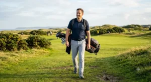 A golfer carrying a lightweight stand bag, designed for comfort and ease while walking 9 holes on a classic British links course.