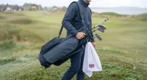 A golfer comfortably carrying a waterproof golf bag with an ergonomic padded shoulder strap.