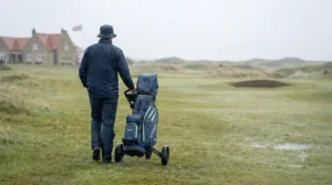 A golfer walking on a course in light rain with their waterproof bag.
