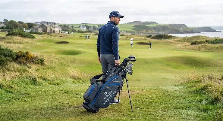 Golfer adjusting the comfortable dual smart-flex carry straps on a Motocaddy HydroFlex stand bag. Motocaddy HydroFlex golf bag