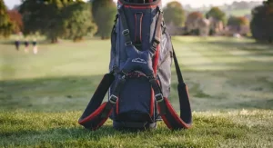 A close-up of a golf bag filled with clubs, highlighting the top arrangement and handles against a golf course backdrop.