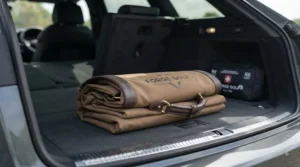 A collapsible and portable golf shag bag folded down neatly next to a golf bag for easy boot storage.