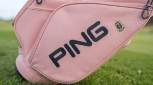 Female golfer walking down a fairway carrying a stylish pink golf bag.