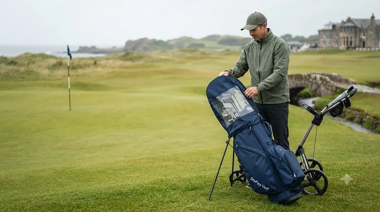 Waterproof golf bag rain cover fitted securely over a trolley bag on a wet British golf course. golf bag rain cover