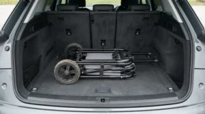 A compact folding push golf trolley packed neatly into the boot of a hatchback vehicle