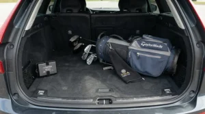 A spare golf trolley battery charger stored neatly in the boot of a family car